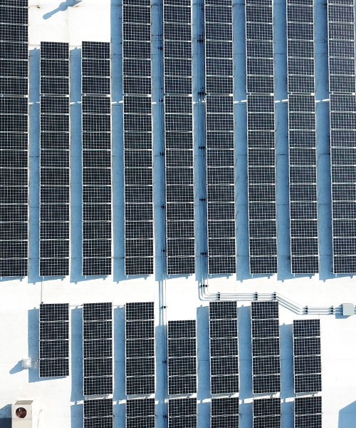 Drone photo of rooftop solar panels mounted on a commercial retail shopping center.