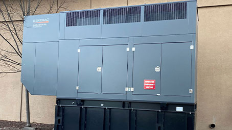 Generator generator made by Generac placed near a commercial and industrial facility.