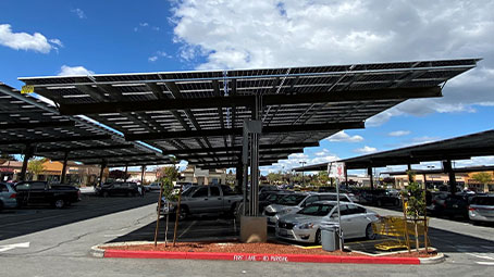 Covered carport solar structures in the parking lot of a commercial retail shopping center.